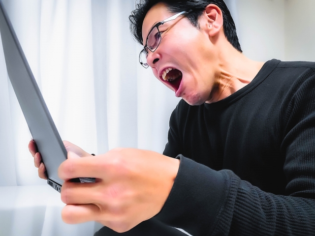 怒りに任せてSNSにコメントを書き込もうとしている男性のイメージ